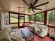 Relaxing screened porch boasts a ceiling fan, comfortable furniture, and views of the lush backyard at 703 Overlook Point, Woodstock, GA 30189