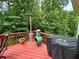 Relax on this deck featuring a Traeger grill, heater, and chiminea surrounded by a wooded backdrop at 703 Overlook Pt, Woodstock, GA 30189