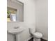 Half bathroom with pedestal sink and modern toilet at 8225 Coldstream Dr, Fairburn, GA 30213