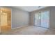 Bedroom with sliding glass door and neutral carpet and paint at 115 Plantation Dr, Clarkston, GA 30021