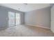 Bedroom with sliding glass door and neutral carpet and paint at 115 Plantation Dr, Clarkston, GA 30021