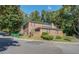 Brick two-story building surrounded by lush trees, shrubs, and a well-manicured lawn at 115 Plantation Dr, Clarkston, GA 30021