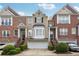 Attractive brick townhome with a two-car garage, manicured bushes, and a well-kept lawn at 1286 Creekside Se Ter, Smyrna, GA 30082