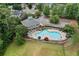 Aerial view of a kidney-shaped community pool with lounge chairs, umbrellas, and a clubhouse surrounded by lush greenery at 150 Northshore Xing, Dallas, GA 30157