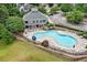 An elevated view of a kidney-shaped pool with lounge chairs, umbrellas, stone wall, and a two-story clubhouse at 150 Northshore Xing, Dallas, GA 30157