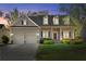 Charming two-story home featuring dormer windows, a covered porch, and well-maintained landscaping at twilight at 150 Northshore Xing, Dallas, GA 30157