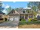 Charming two-story home featuring dormer windows, a covered porch, and well-maintained landscaping at 150 Northshore Xing, Dallas, GA 30157