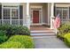 Inviting covered front porch with white columns, wood decking, and lush landscaping at 150 Northshore Xing, Dallas, GA 30157
