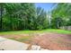 A sprawling backyard with mature trees, lush greenery, and a wood fence. Ideal for outdoor activities at 20 Cheryl Ter, Covington, GA 30016