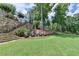 Backyard seating area on manicured lawn surrounded by mature trees and landscaping at 4745 Cuyahoga Cv, Suwanee, GA 30024