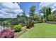 Scenic backyard with a bench overlooking the water, surrounded by trees and greenery at 4745 Cuyahoga Cv, Suwanee, GA 30024