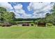 Manicured backyard overlooks a lake and golf course beyond wrought iron fence at 4745 Cuyahoga Cv, Suwanee, GA 30024