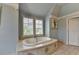 Bright bathroom features a soaking tub with natural light, set against neutral tile work at 4745 Cuyahoga Cv, Suwanee, GA 30024