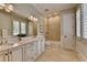 Bright bathroom featuring double vanity, soaking tub, and neutral tile flooring and includes plantation shutters at 4745 Cuyahoga Cv, Suwanee, GA 30024