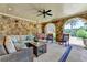 Outdoor living area features stone archways, wicker furniture, ceiling fan, and an outdoor swing at 4745 Cuyahoga Cv, Suwanee, GA 30024