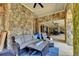 Covered patio featuring stone columns, wicker furniture, stone floor, and recessed lighting at 4745 Cuyahoga Cv, Suwanee, GA 30024