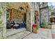 Covered patio featuring stone columns, wicker furniture, stone floor, and manicured yard at 4745 Cuyahoga Cv, Suwanee, GA 30024