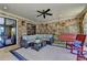 Covered patio with stone accent walls, wicker furniture, ceiling fan, and an outdoor swing at 4745 Cuyahoga Cv, Suwanee, GA 30024