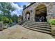 Stone exterior features multiple levels, covered patio with ceiling fans, and garden area at 4745 Cuyahoga Cv, Suwanee, GA 30024