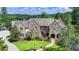 Stunning stone-and-brick home featuring a manicured lawn and a stone walkway leading to an arched front entrance at 4745 Cuyahoga Cv, Suwanee, GA 30024