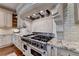 Close up of a gourmet stove with custom hood, granite counters and custom cabinets at 4745 Cuyahoga Cv, Suwanee, GA 30024
