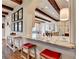 Bright, open kitchen featuring a breakfast bar with red stools and wooden beam accents at 4745 Cuyahoga Cv, Suwanee, GA 30024