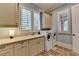 Well-equipped laundry room featuring a sink, countertop, storage cabinets, and a stacked washer and dryer at 4745 Cuyahoga Cv, Suwanee, GA 30024