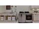 Well-organized laundry room with modern, front-loading washer and dryer, ample counter space, and convenient storage solutions at 4745 Cuyahoga Cv, Suwanee, GA 30024