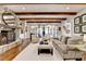 Comfortable living room with stone fireplace, exposed beams, and access to a patio with seating at 4745 Cuyahoga Cv, Suwanee, GA 30024