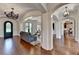 Elegant living room featuring hardwood floors, arched doorways, and a decorative chandelier at 4745 Cuyahoga Cv, Suwanee, GA 30024