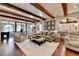 Living room with exposed beams and stone fireplace, flowing to outdoor living, dining and kitchen areas at 4745 Cuyahoga Cv, Suwanee, GA 30024