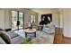 Bright living room with large windows, comfortable seating, and view of the backyard at 4745 Cuyahoga Cv, Suwanee, GA 30024