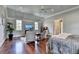 Bright main bedroom featuring sitting area with two chairs, hardwood floors, and a ceiling fan at 4745 Cuyahoga Cv, Suwanee, GA 30024