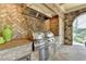 Stainless steel grill in outdoor kitchen with brick detail and lush backyard views at 4745 Cuyahoga Cv, Suwanee, GA 30024