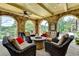 Covered outdoor patio featuring a seating area with plush seating and a stone arch surround at 4745 Cuyahoga Cv, Suwanee, GA 30024