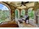 Cozy covered patio with stone arches and comfortable wicker seating overlooking lush greenery at 4745 Cuyahoga Cv, Suwanee, GA 30024
