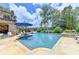 Stunning pool and patio area with lounge chairs, lush landscaping, and nearby stone house at 4745 Cuyahoga Cv, Suwanee, GA 30024