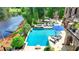 A pristine pool and spa area nestled next to the lake are surrounded by lush landscaping and luxurious patio furniture at 4745 Cuyahoga Cv, Suwanee, GA 30024