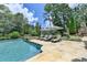 Resort-style pool and lounge area with spa, lush trees, and outdoor fireplace for relaxation at 4745 Cuyahoga Cv, Suwanee, GA 30024