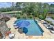 Backyard pool area features a pool, hot tub, lounge seating, umbrella, and golf course view at 4745 Cuyahoga Cv, Suwanee, GA 30024