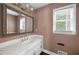 Bathroom vanity features a framed mirror, white cabinets and a large window at 2108 Yorkshire Ct, Woodstock, GA 30189
