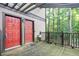 Charming condo entrance with red doors, rustic wood deck, and a view of surrounding greenery at 408 River Run Dr, Sandy Springs, GA 30350