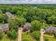 Aerial view of a brick home nestled among lush trees in a tranquil neighborhood setting at 610 Woodstream Ct, Roswell, GA 30075