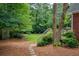 Landscaped backyard with a stone pathway, lush greenery, and a mulched garden area at 610 Woodstream Ct, Roswell, GA 30075