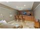 Finished basement showcasing a wooden bar with seating, a mounted TV, and stylish decor at 610 Woodstream Ct, Roswell, GA 30075