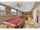 Spacious basement with a red pool table, a built-in bar area, and large windows providing natural light at 610 Woodstream Ct, Roswell, GA 30075