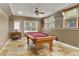 Large basement featuring a red pool table, tile flooring, and multiple windows, ideal for entertaining at 610 Woodstream Ct, Roswell, GA 30075