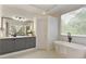Bright bathroom with modern tub, gray vanity, and a large window at 610 Woodstream Ct, Roswell, GA 30075