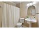 Cozy bathroom with a pedestal sink, large mirror, and a shower with a white curtain at 610 Woodstream Ct, Roswell, GA 30075