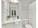 Bright bathroom with a white single sink vanity, a large mirror, and a bathtub with a shower curtain at 610 Woodstream Ct, Roswell, GA 30075